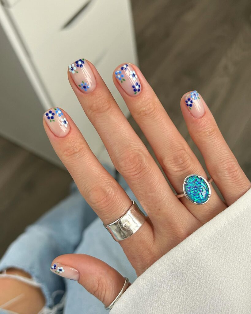 Sheer nude nails with blue forget-me-not flower art