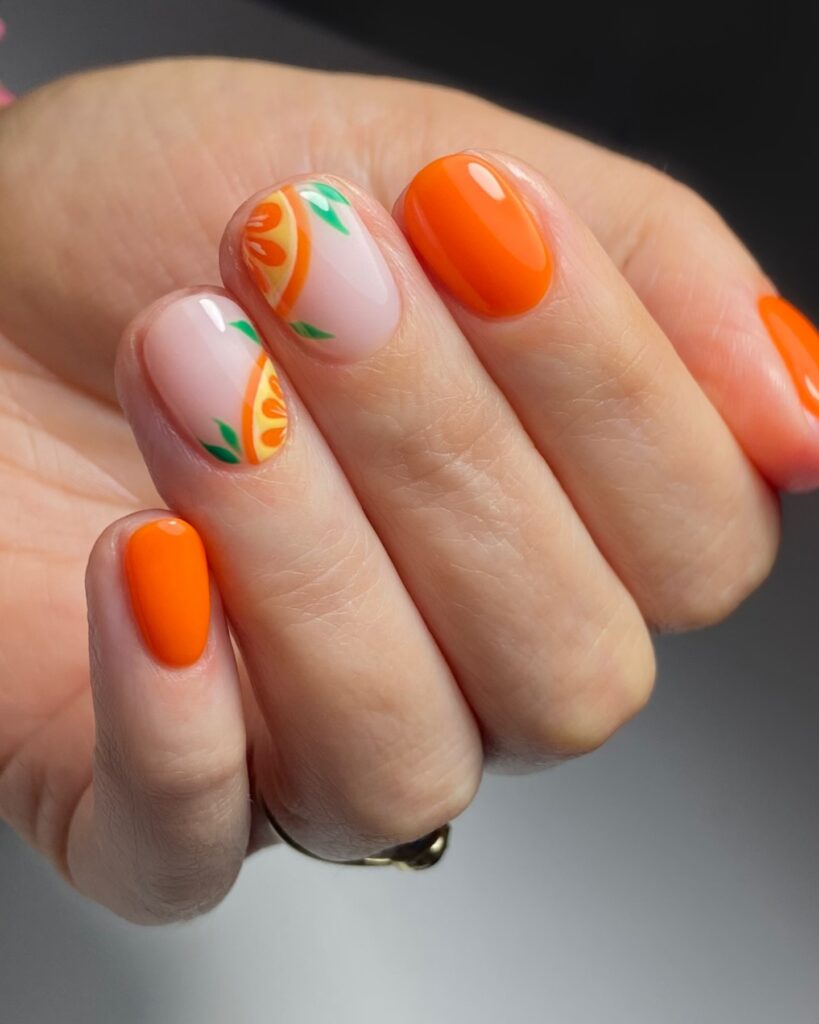 Orange coral nails with citrus slice accent