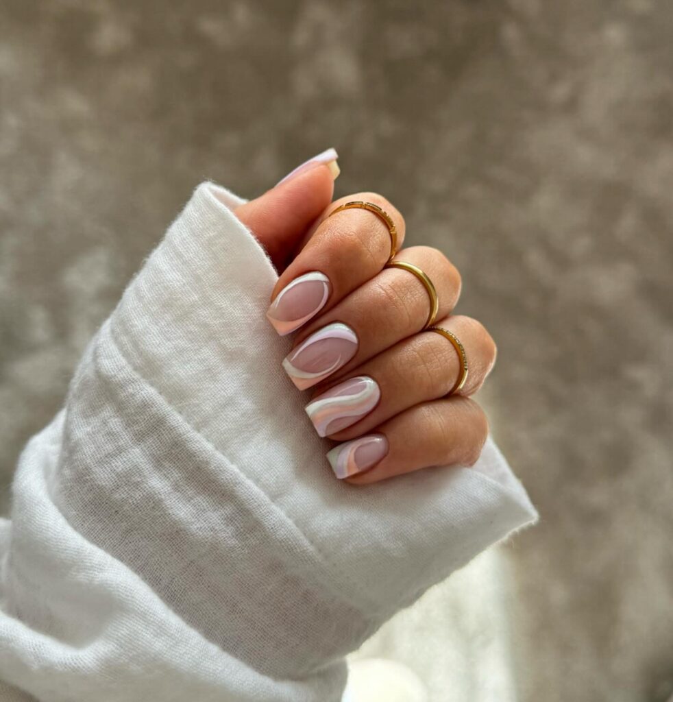 Nude nails with white swirl French manicure