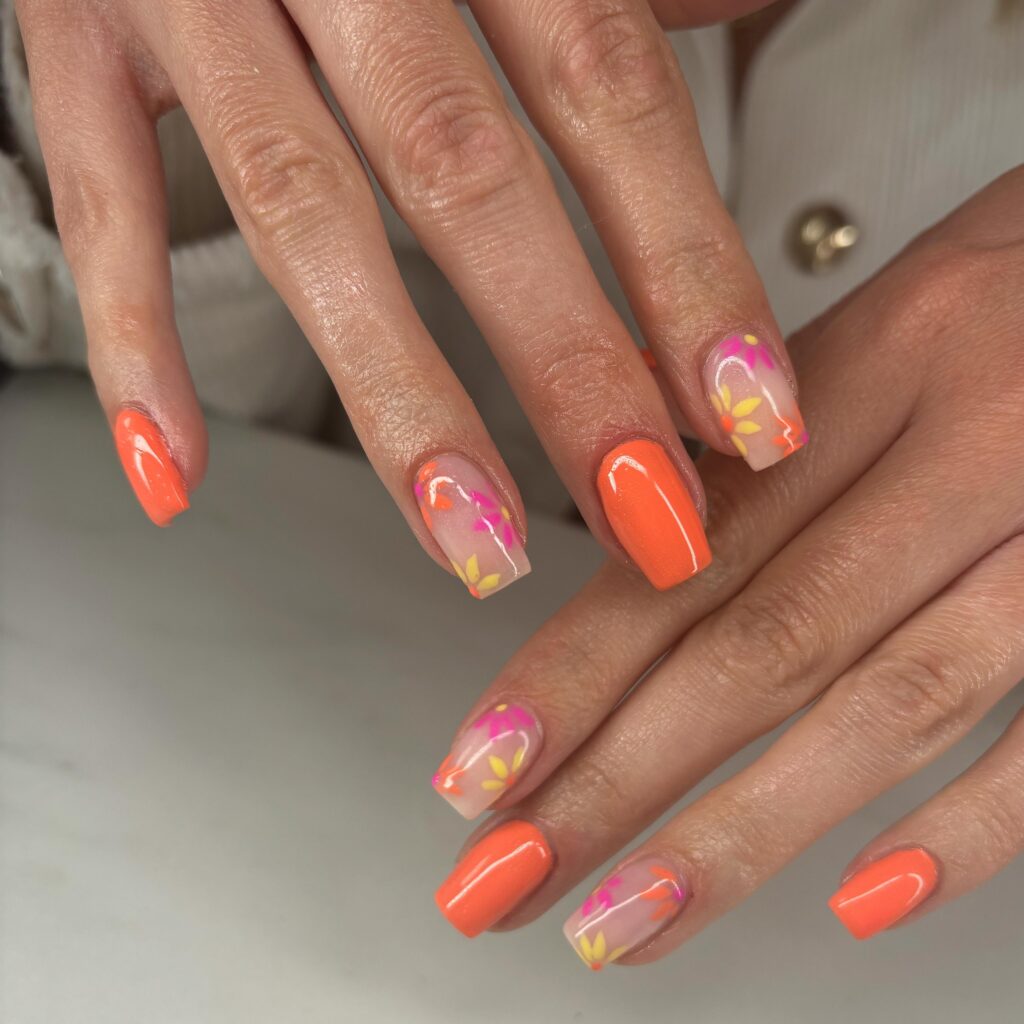 Neon coral nails with tropical floral accent