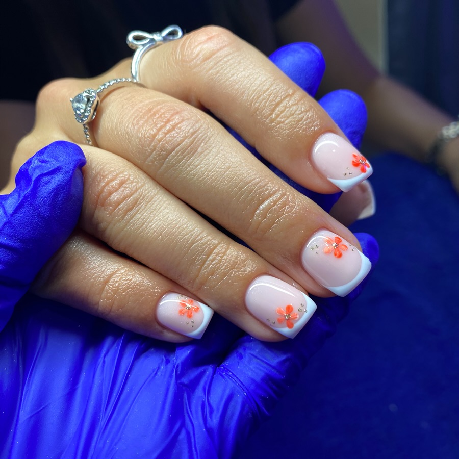 Nude nails with white French tips and coral flower art