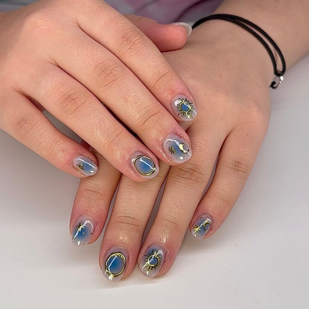 Sheer nails with gold celestial sun moon and star art