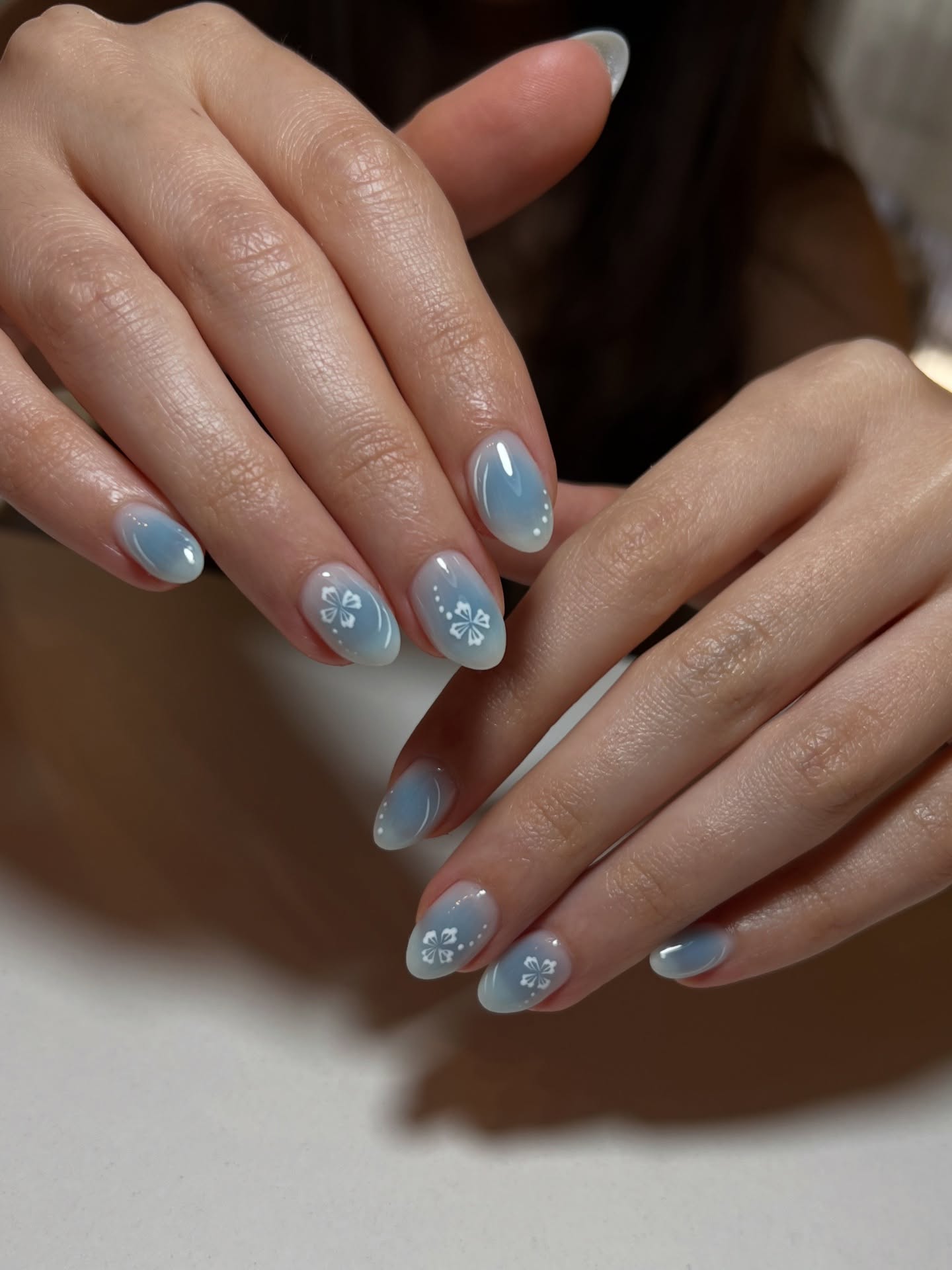 Baby blue aura gradient with white hibiscus nail art