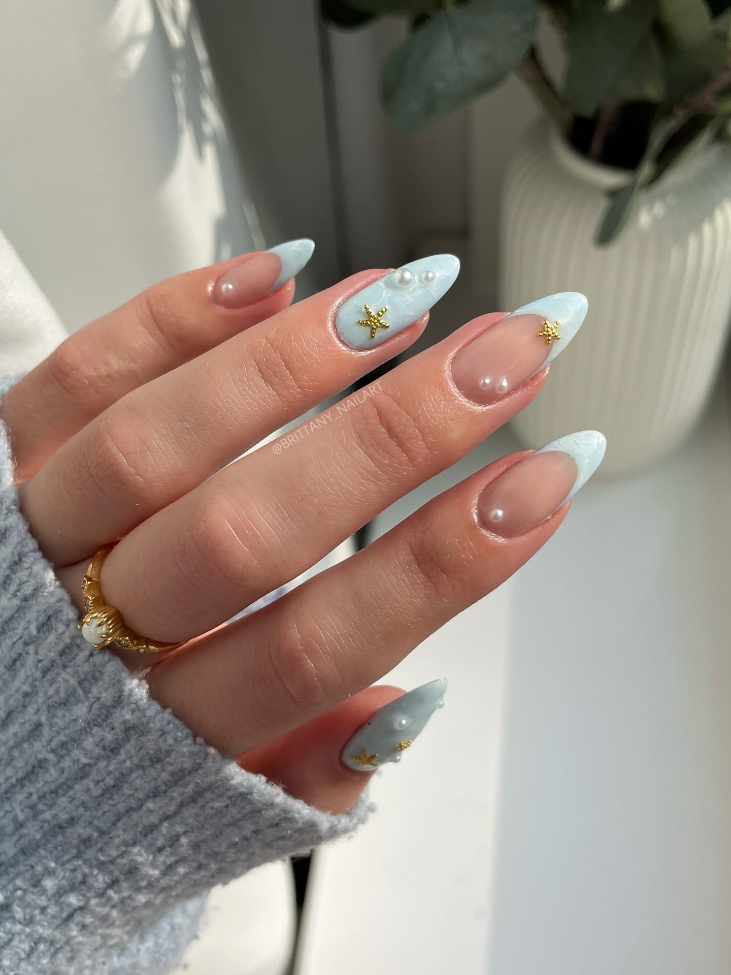 Baby blue French tip almond nails with pearl beads and gold starfish