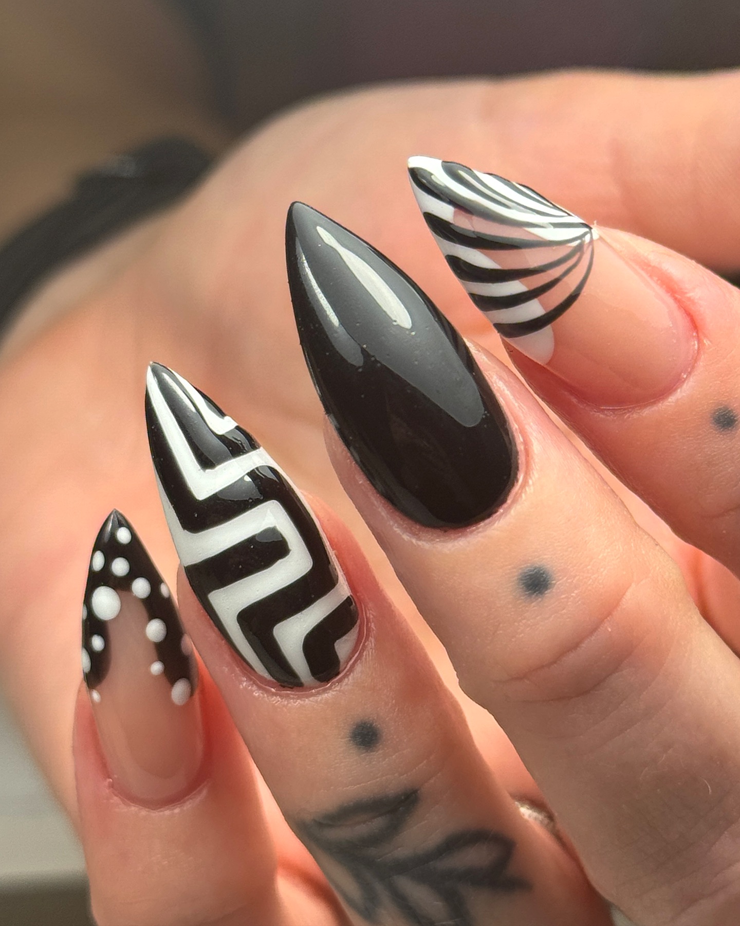 Long stiletto nails with mixed black and white geometric patterns