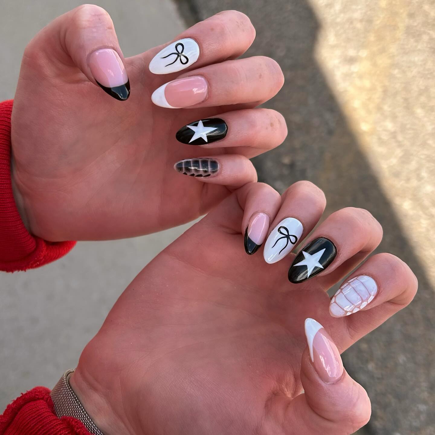 Mixed black and white nail art with stars, bow, French tip and grid accents