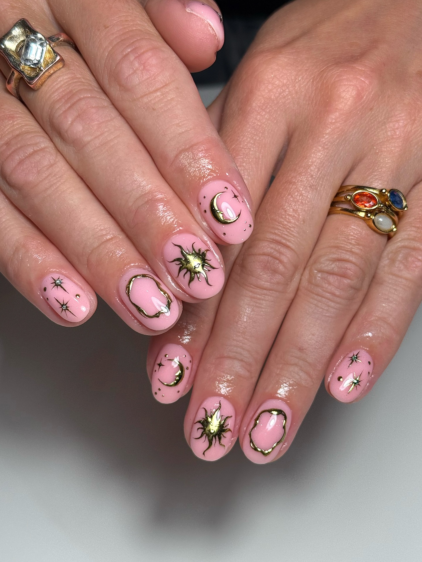 Blush pink nails with gold sun moon and star art