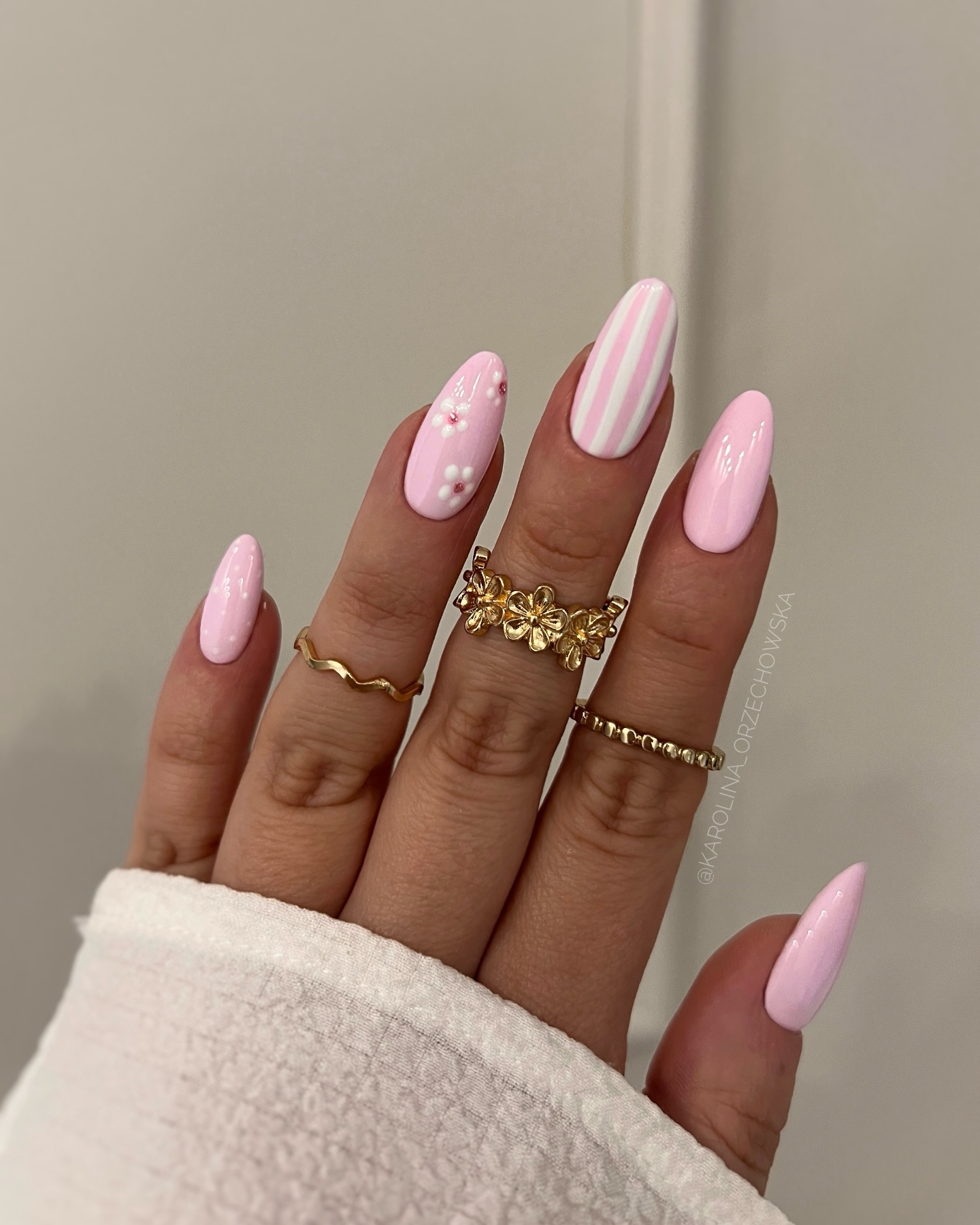 Bubblegum pink almond nails with candy stripe and white daisy accents by Karolina Orzechowska