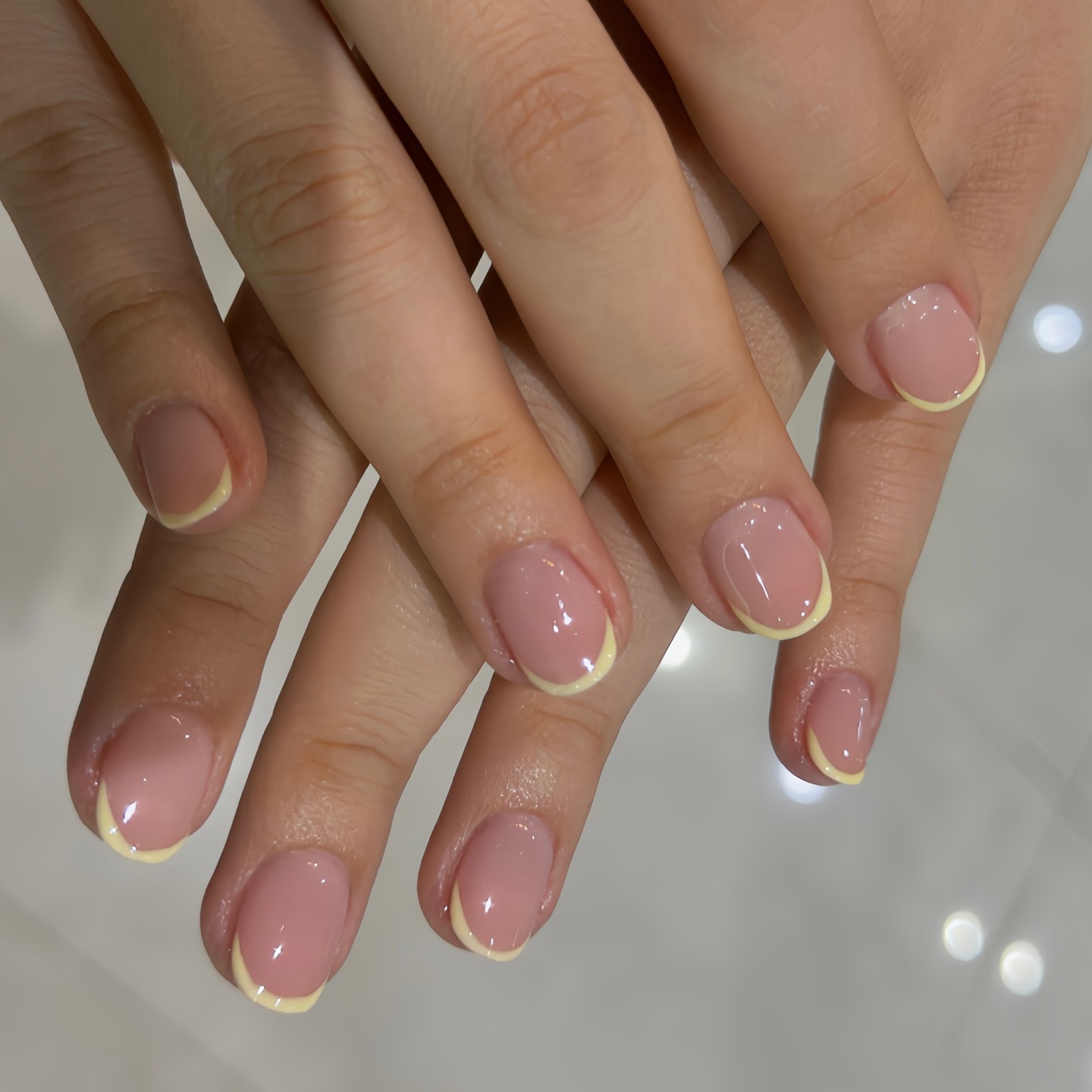 Sheer pink nails with butter yellow French tips