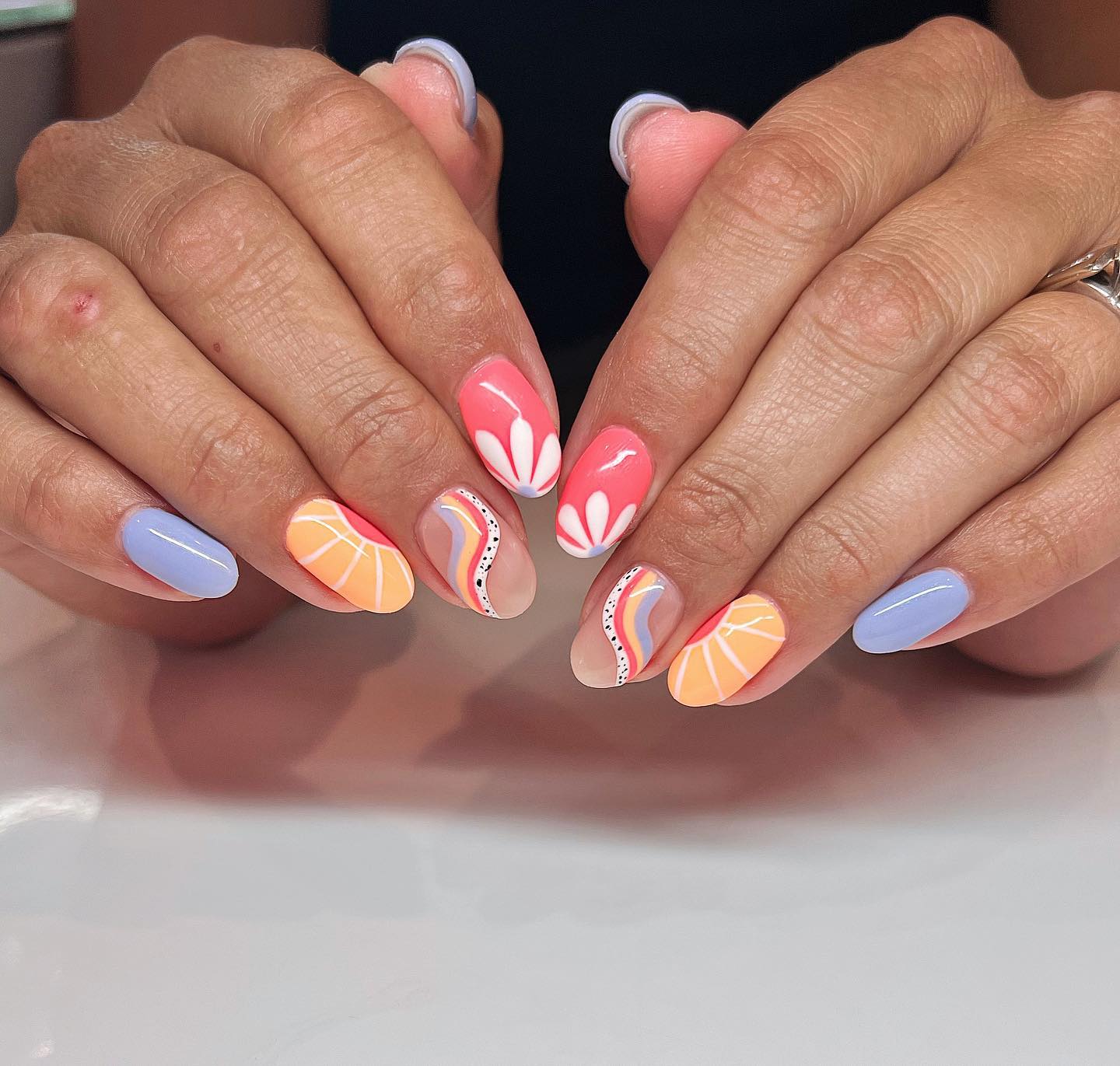 Coral orange and periwinkle nails with tropical petal flowers