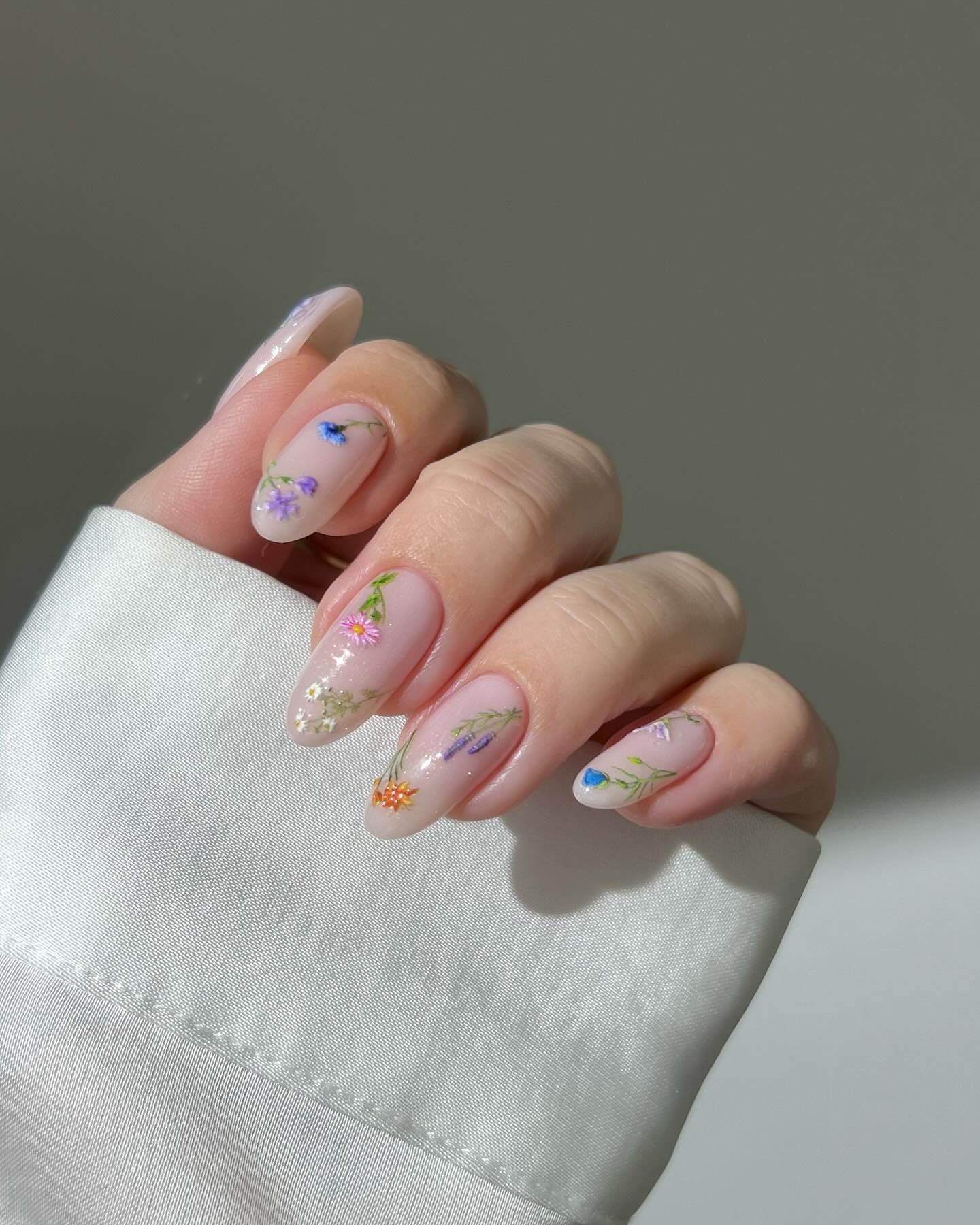 Sheer almond nails with tiny painted wildflowers