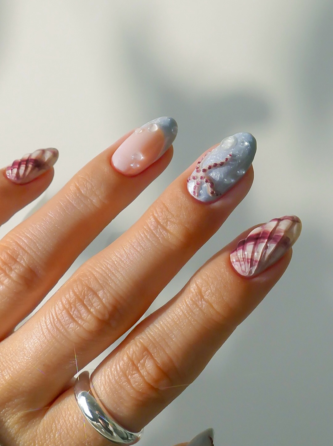 Dusty blue marble almond nails with mauve conch shell ridges