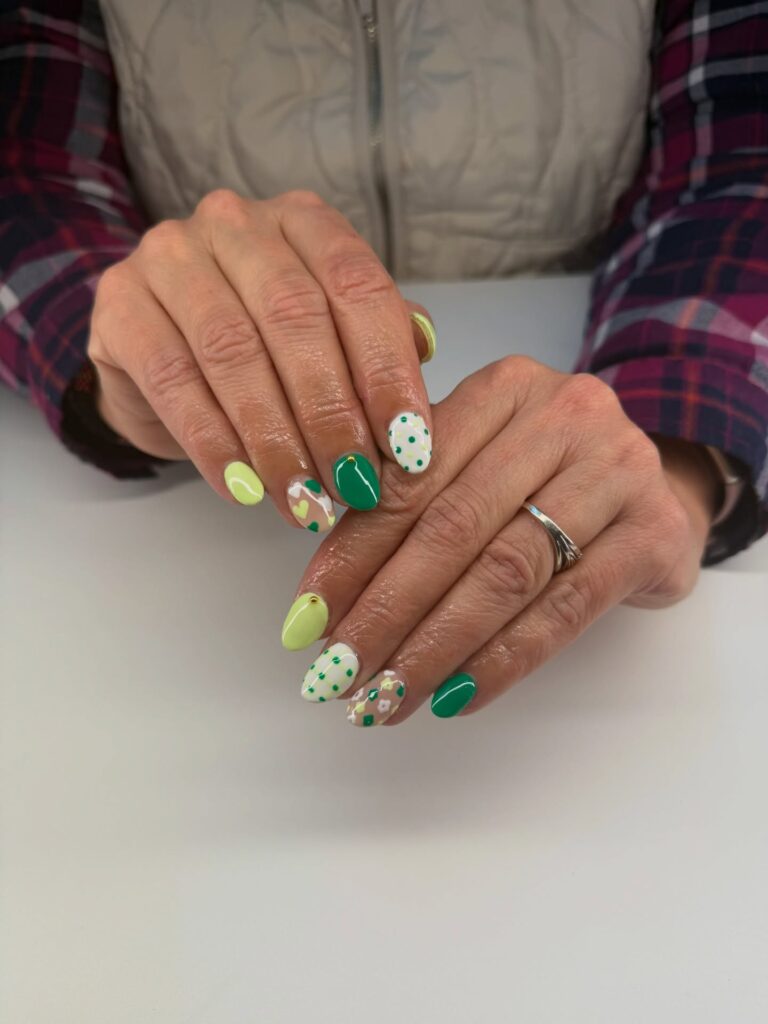 Short nails in mixed green mosaic style with lime, emerald, polka dots and floral art

