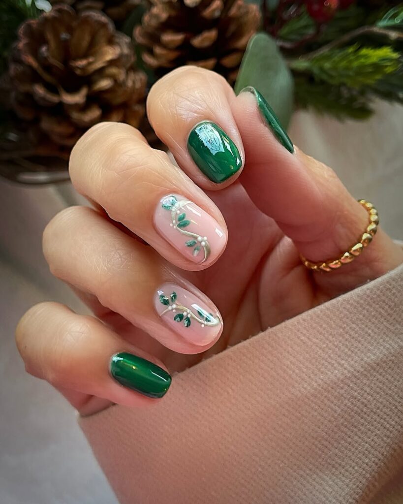 Glossy green spring nails with delicate leaf nail art on a soft nude base