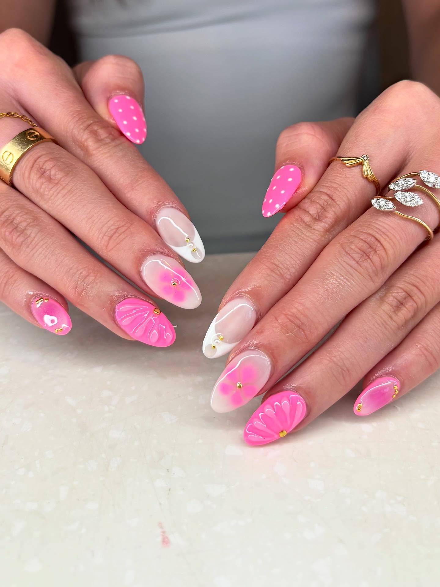 Hot pink almond nails with white 3D shell motif raised gel art and gold studs