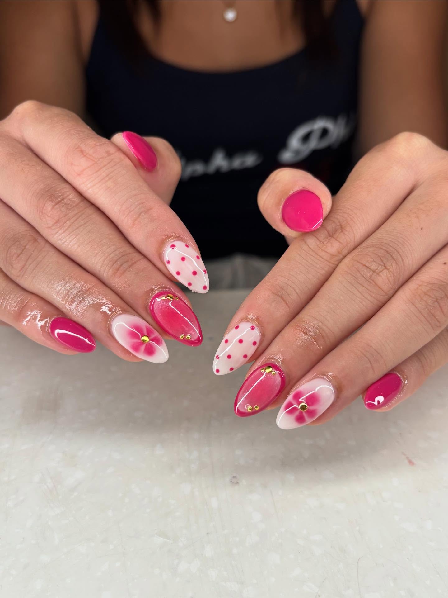 Hot pink almond nails with white floral and polka dot accents