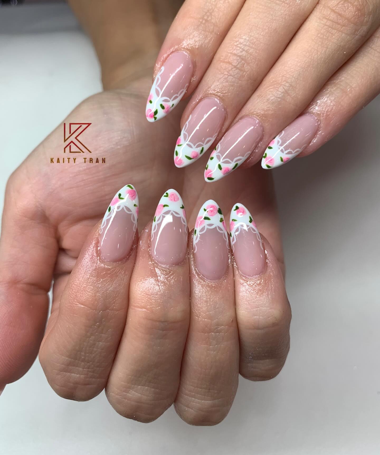 Long stiletto nails with white lace French tip border and tiny hand-painted pink roses