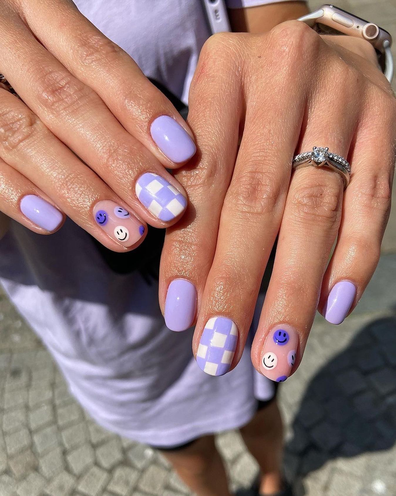 Lavender nails with checkerboard and smiley face accents