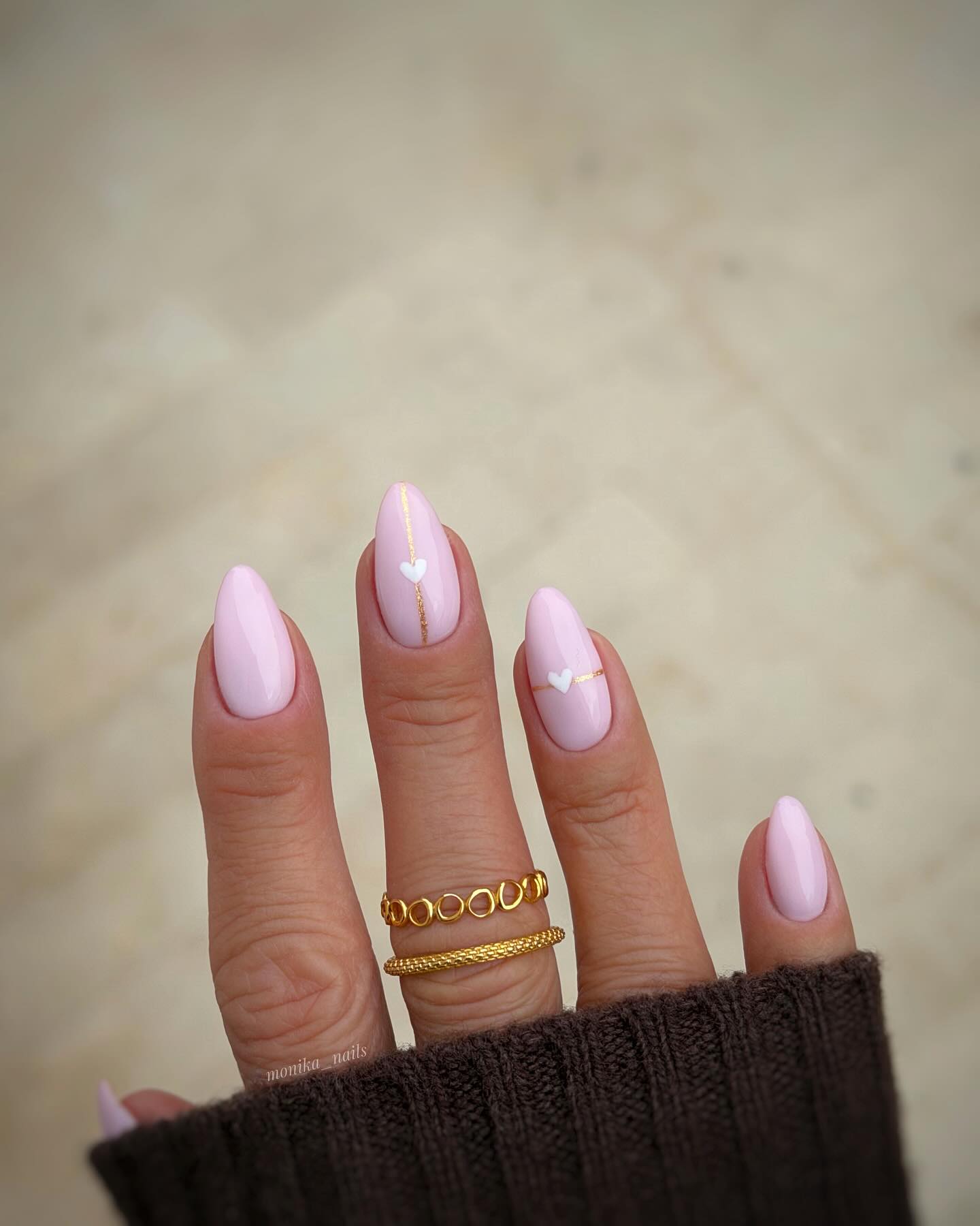 Lavender pink almond nails with gold foil line and white heart detail by Monika Mrózek
