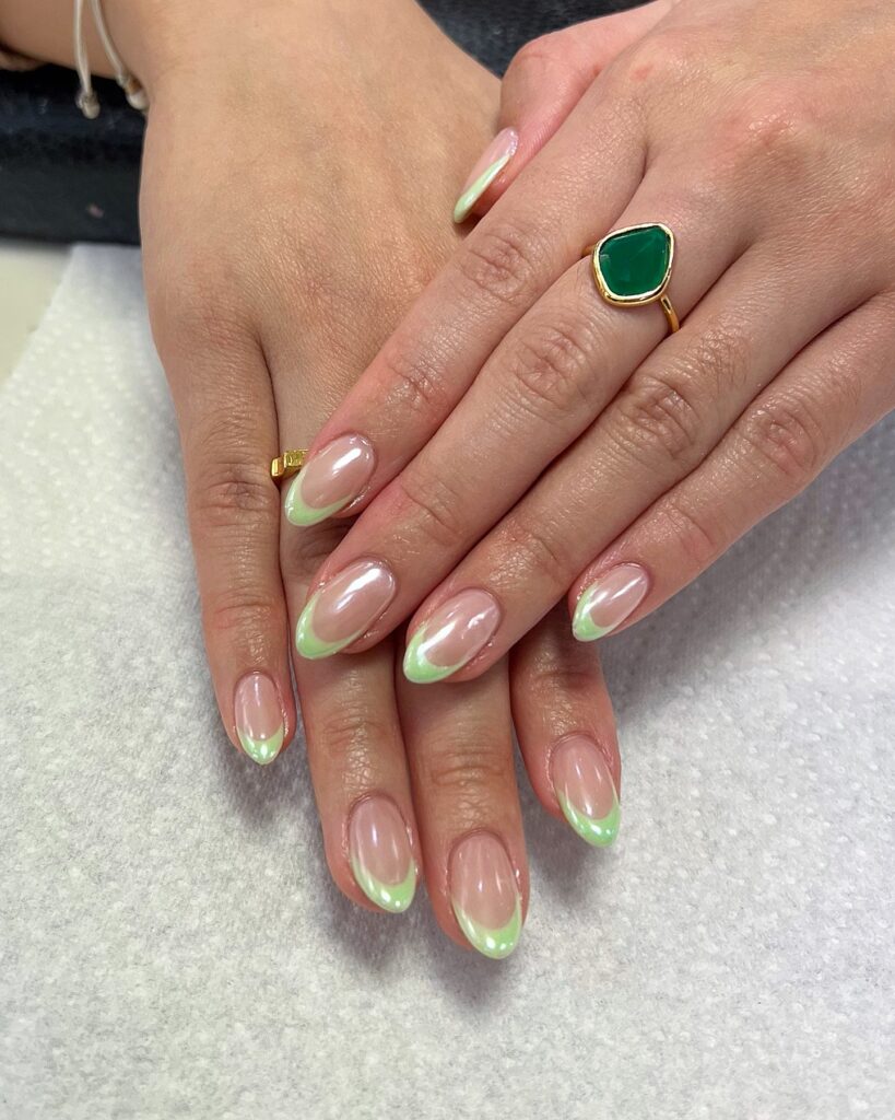 Long almond nails with soft neon lime green French tips on a sheer nude base

