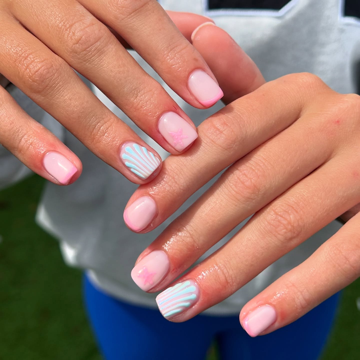 Milky pink nails with pastel blue fan and butterfly accents