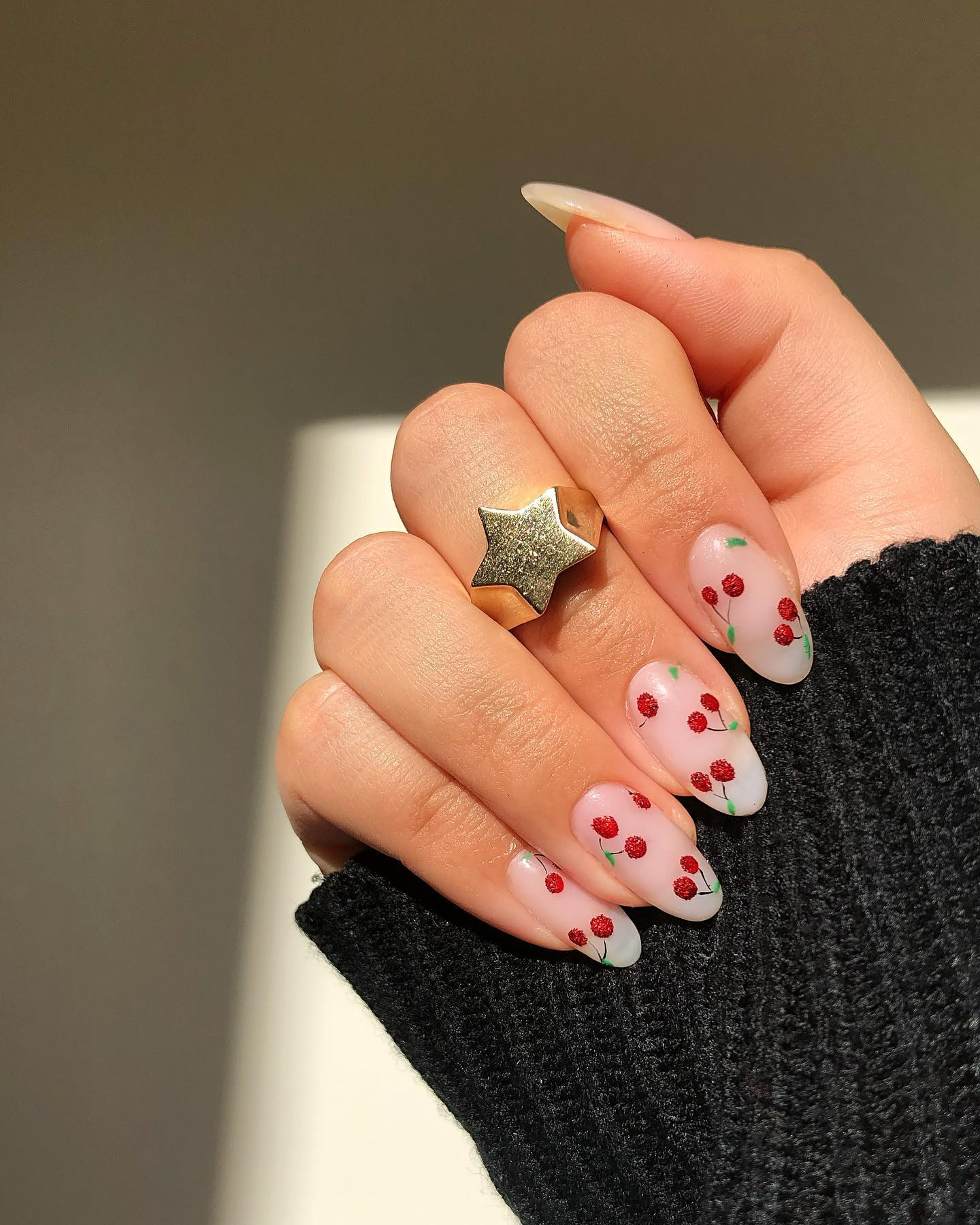 Milky sheer almond nails with textured red berry clusters