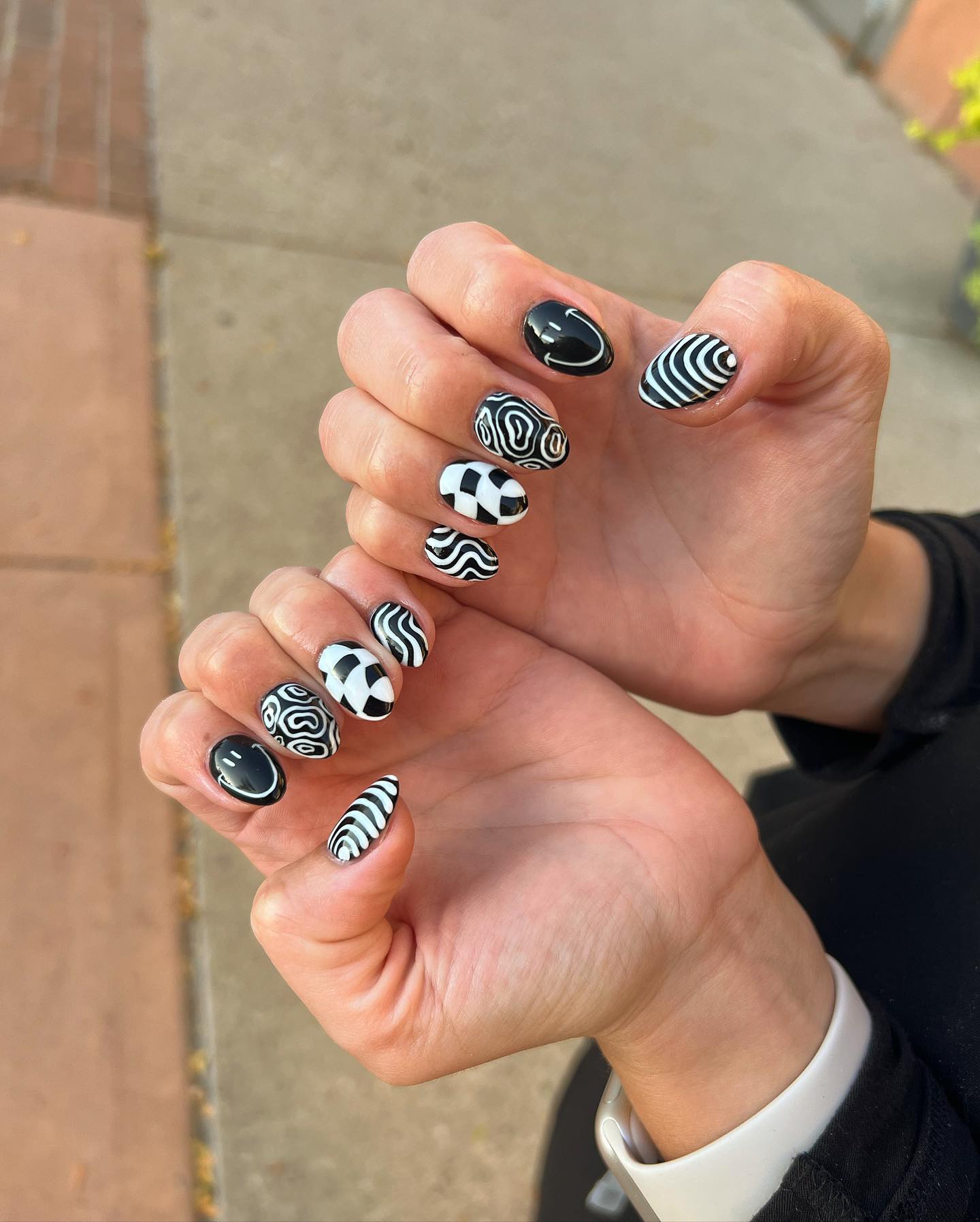 Black and white mixed pattern nails with checkerboard, stripes and swirls