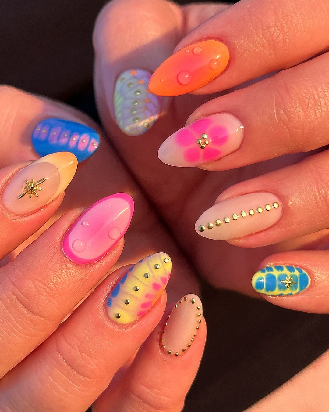 Bright neon almond nails in tie dye and rhinestone festival mix
