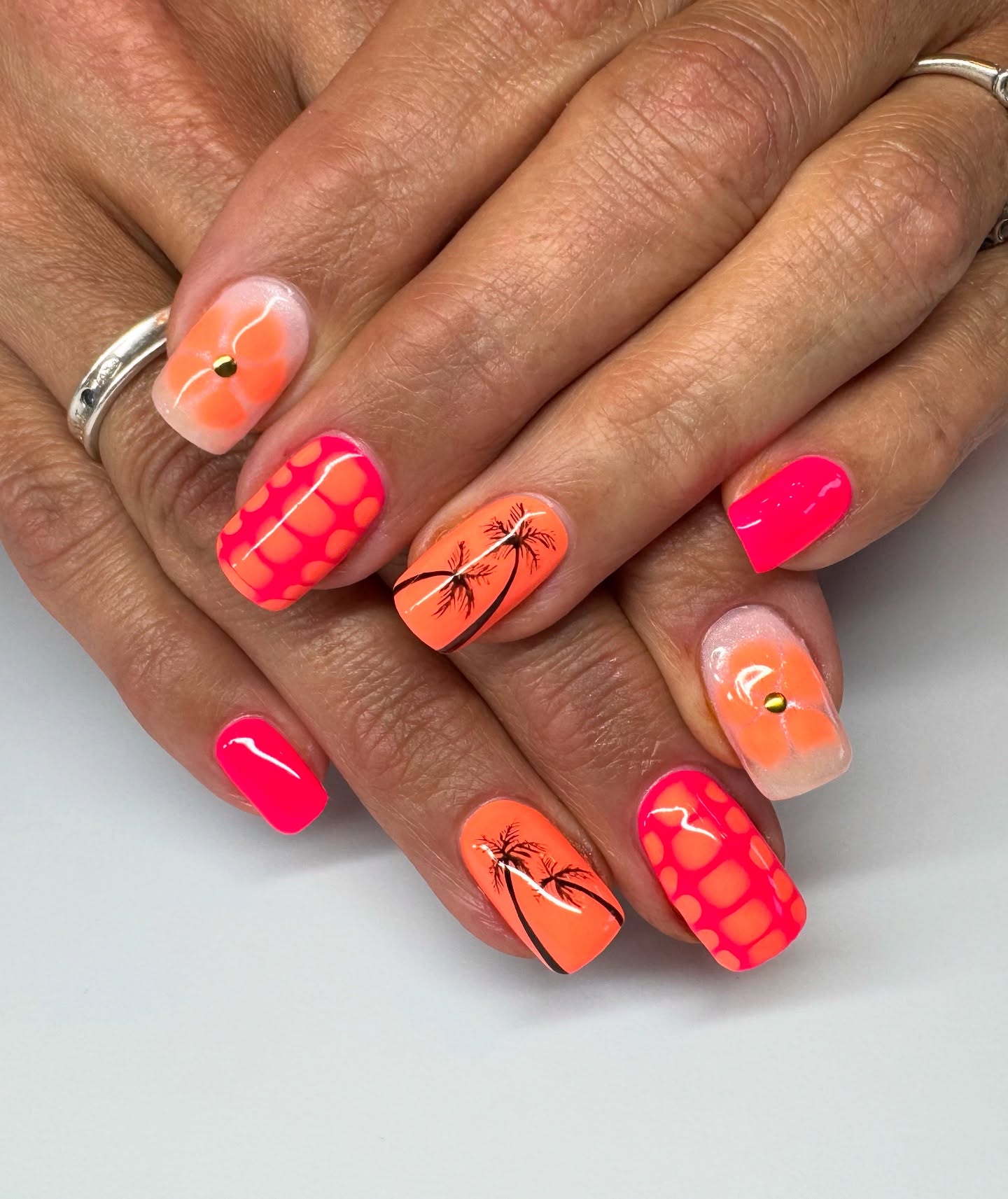 Neon orange and pink nails with palm tree silhouette