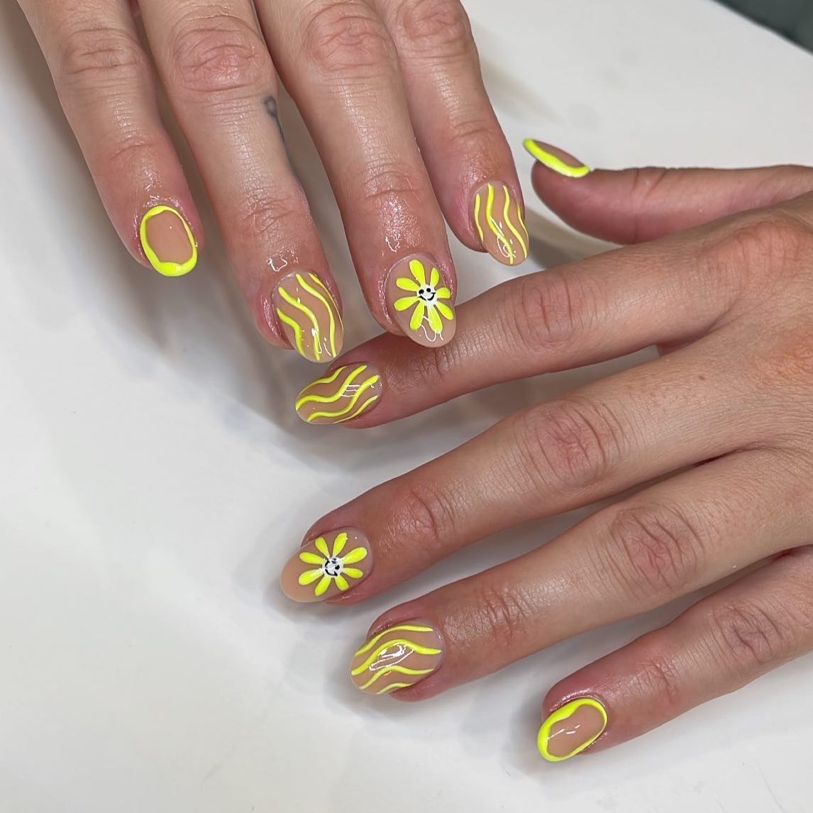 Neon yellow wave lines and smiley face daisy nail art