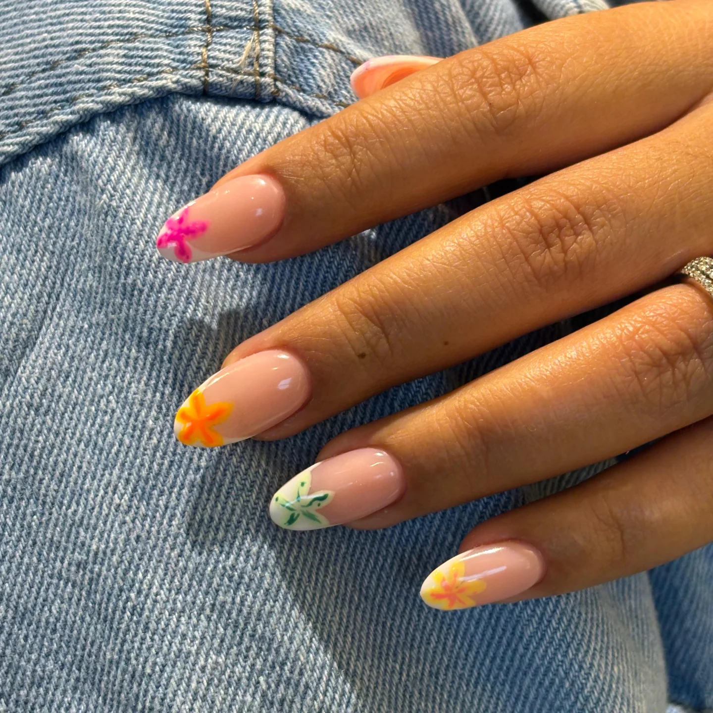 Nude almond nails with neon floral corner accent art