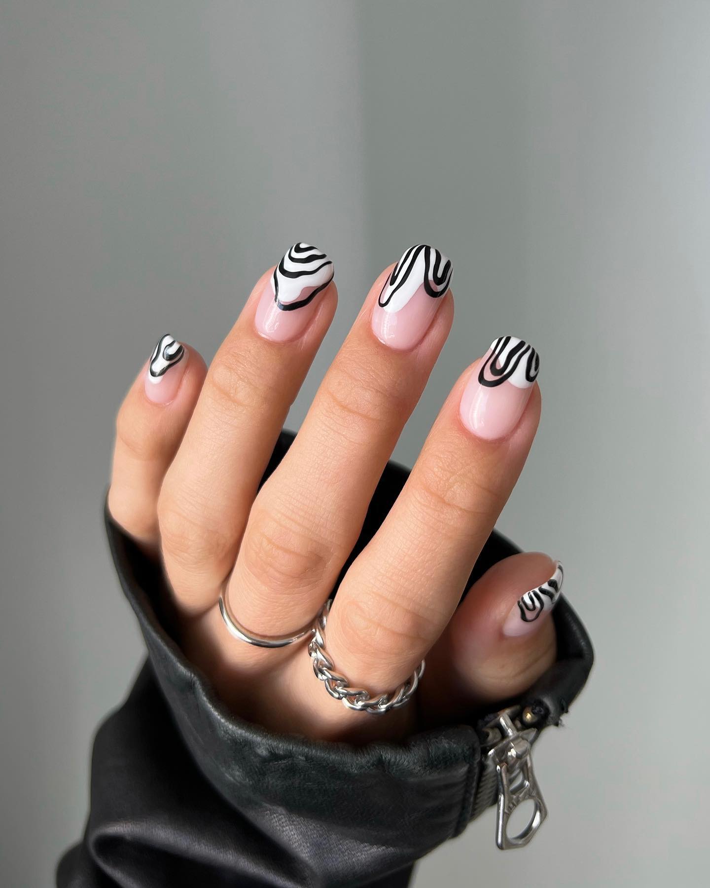 Nude nails with black swirl and wave tip designs