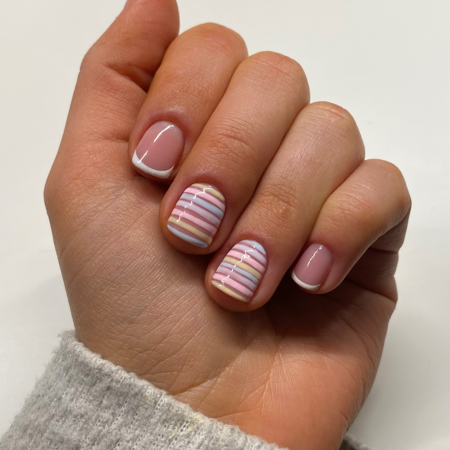 Nude French tips with pastel multicolour stripe accent nails