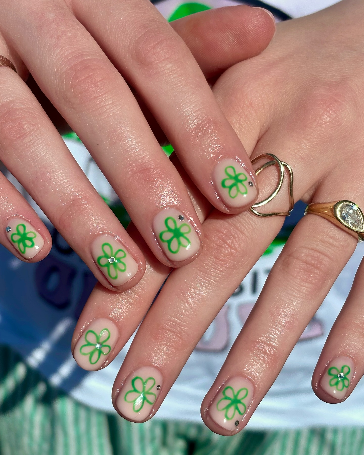 Nude nails with green outline daisy and rhinestone centre