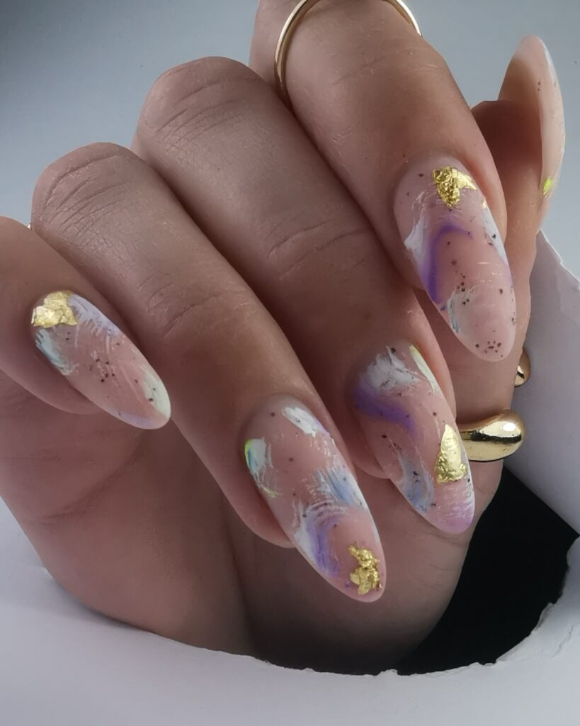 nails with purple watercolor swirls and gold foil flakes