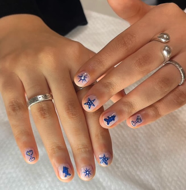 Hand-drawn navy ocean art on white nail base