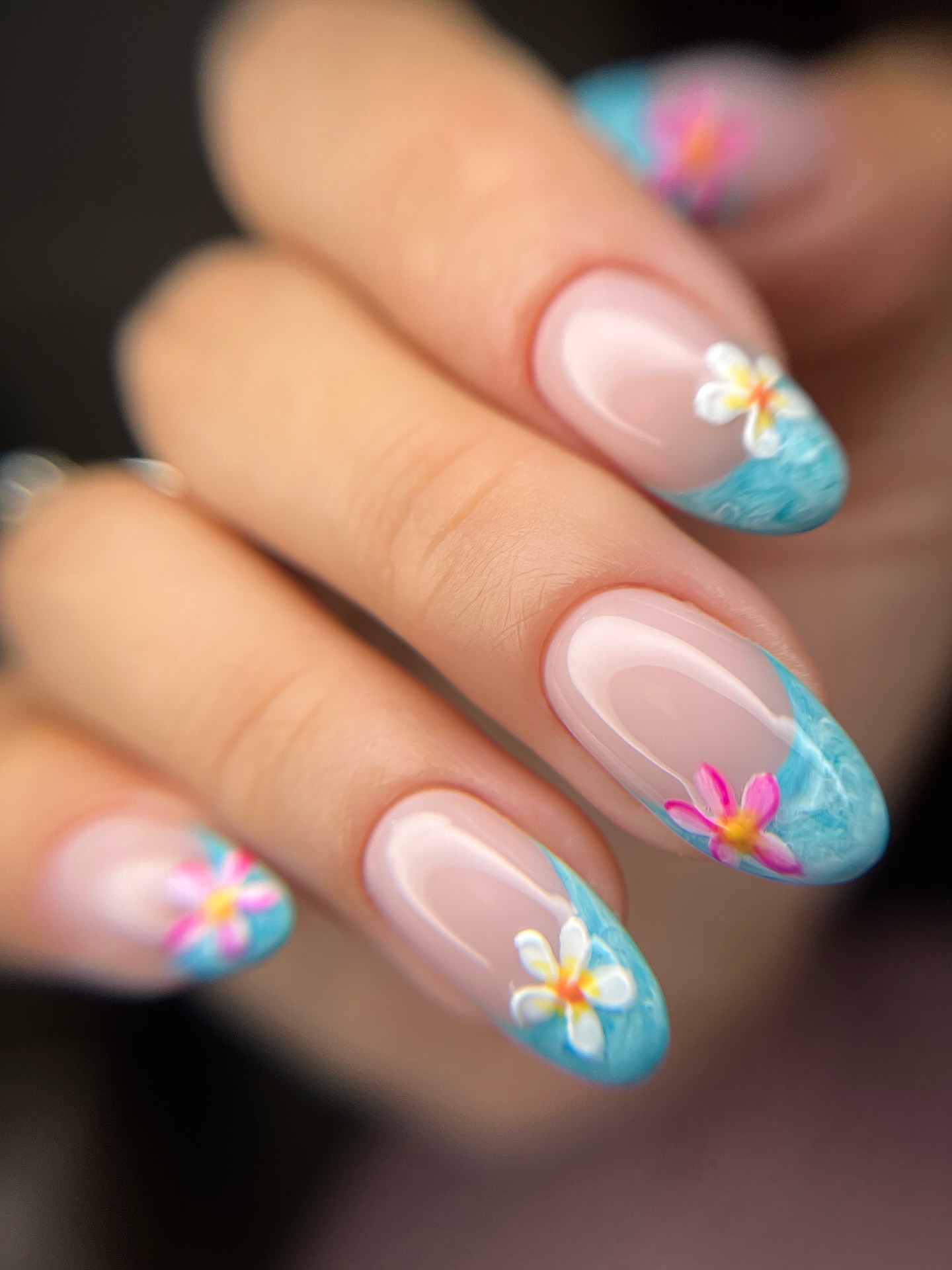 Sheer almond nails with sky blue ocean French tips and plumeria