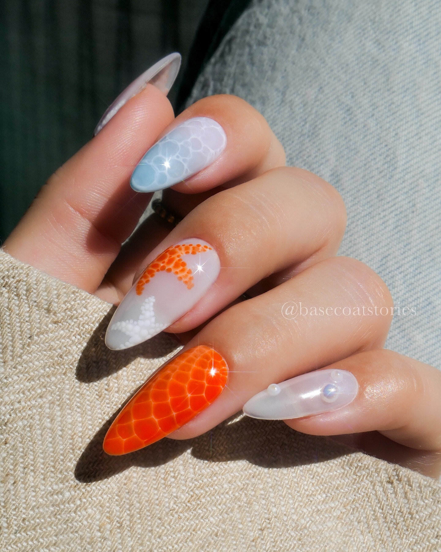 Mixed almond nails with orange fish-scale texture, orange starfish and iridescent pearl