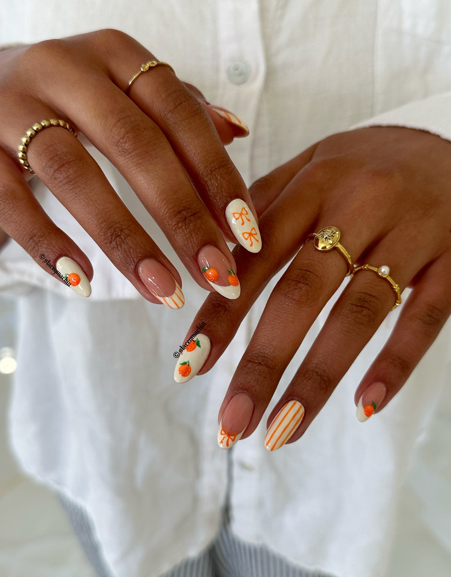 Cream almond nails with painted oranges, bows and stripes
