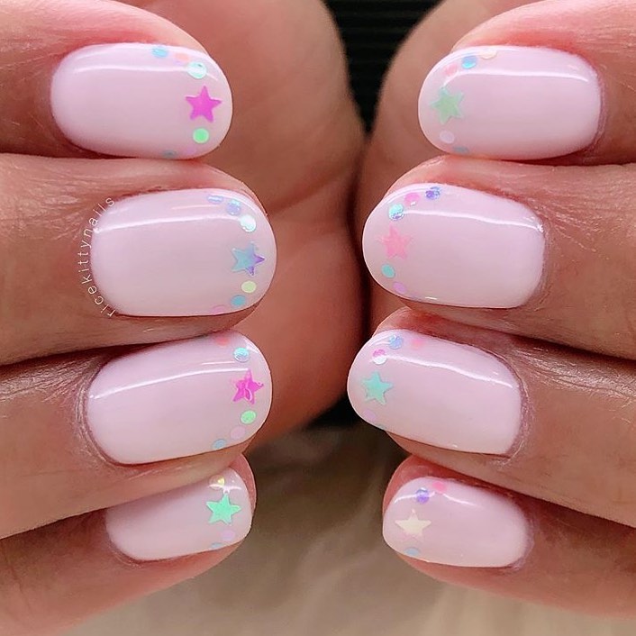 Pale pink nails with iridescent star confetti
