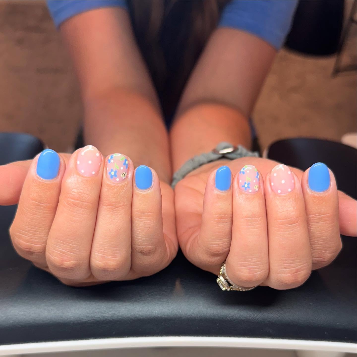 Short periwinkle blue nails with floral accent