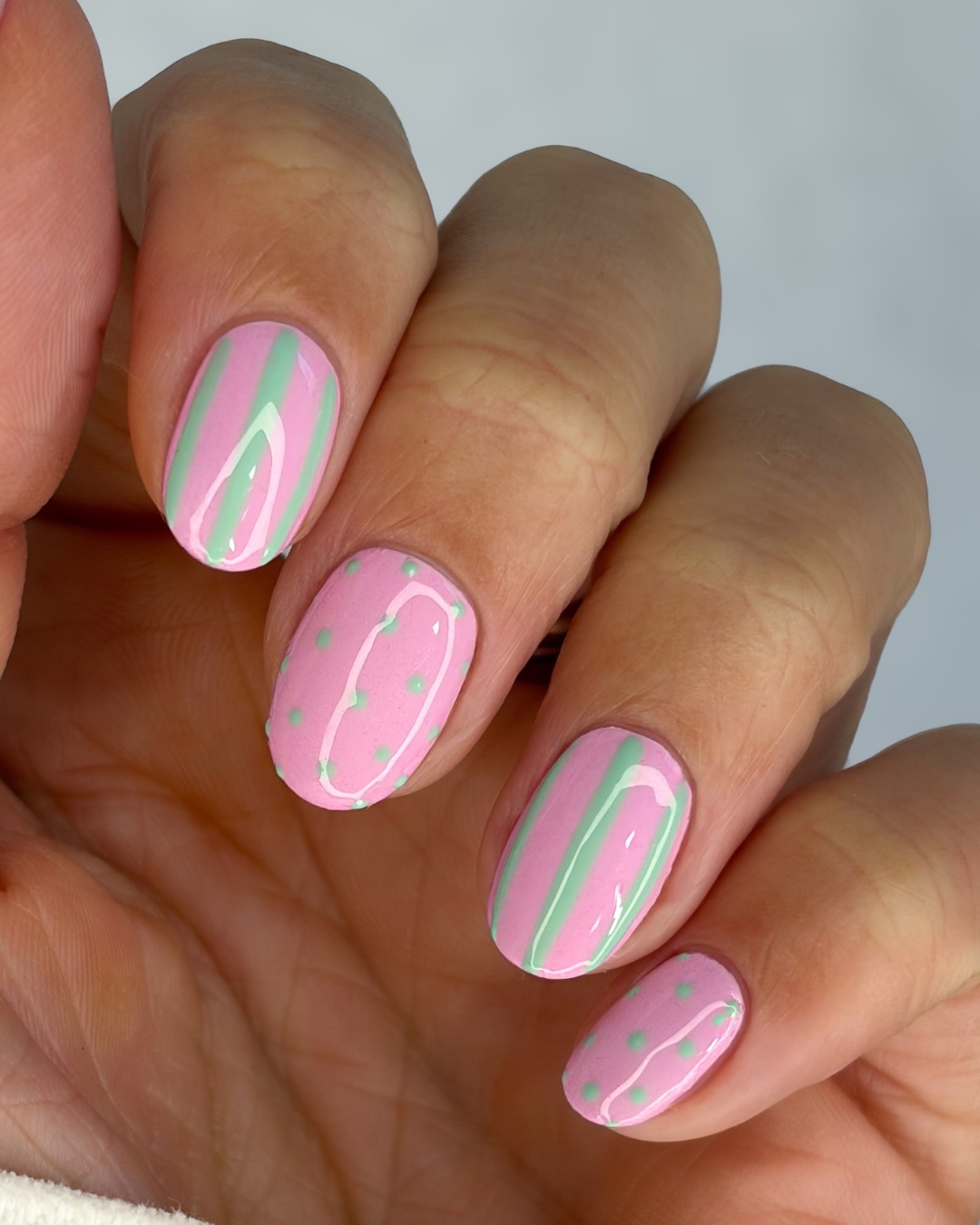 Pink nails with sage green stripe and polka dot art