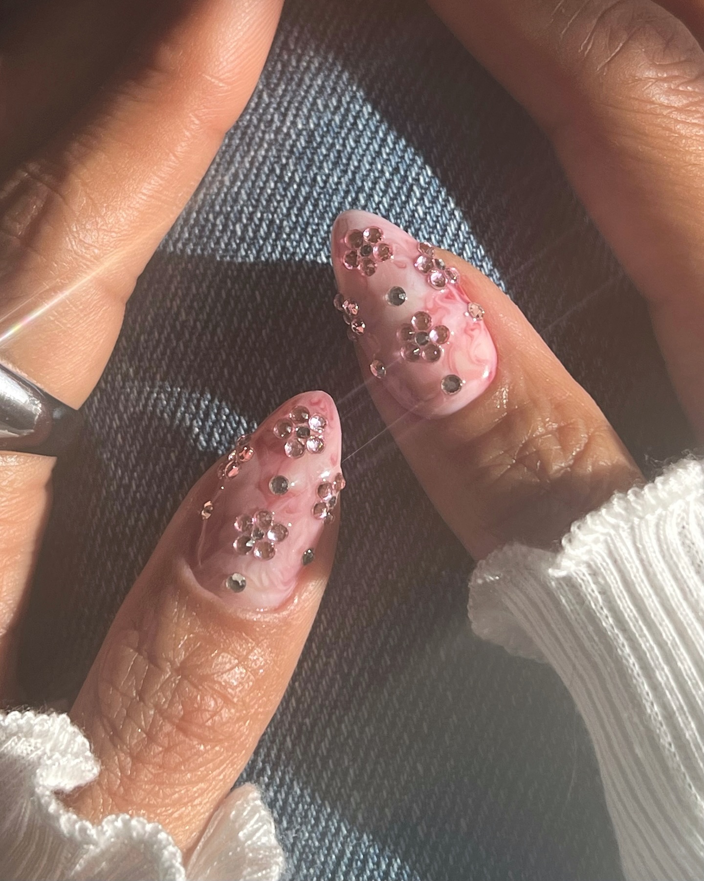 Pink marble nails with rhinestone flower clusters