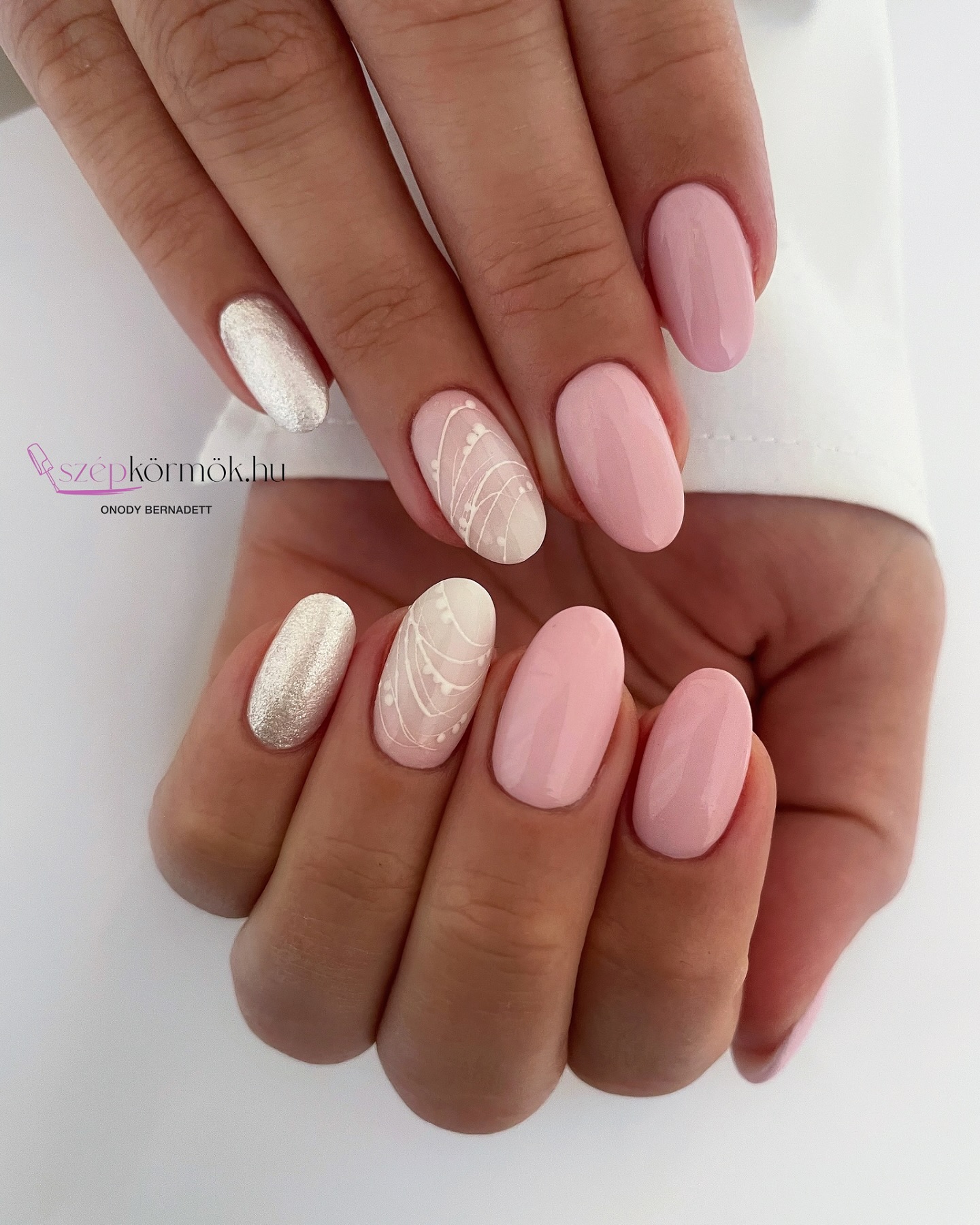 Pink oval nails with silver chrome accent and white lace swirl detail