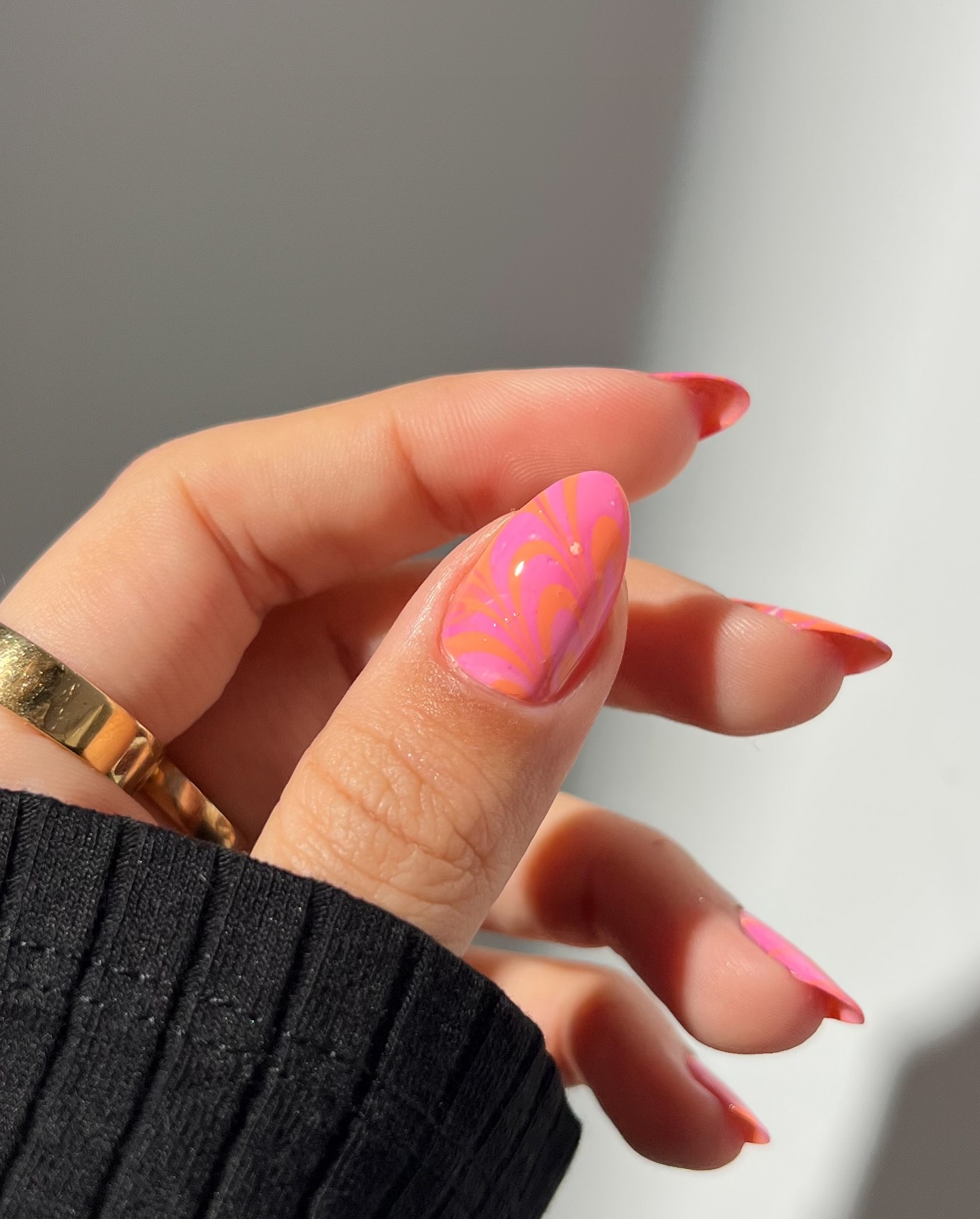 Pink and orange swirl art on single accent nail