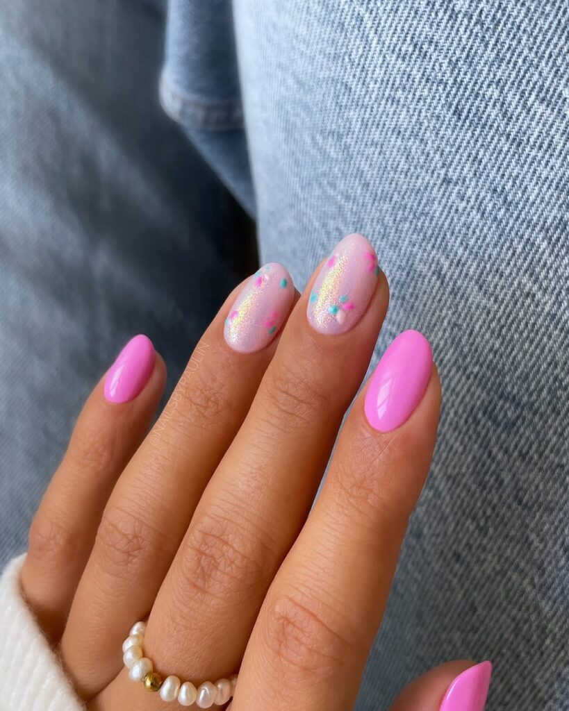 Glossy pink spring nails with shimmer accent and colorful dot details