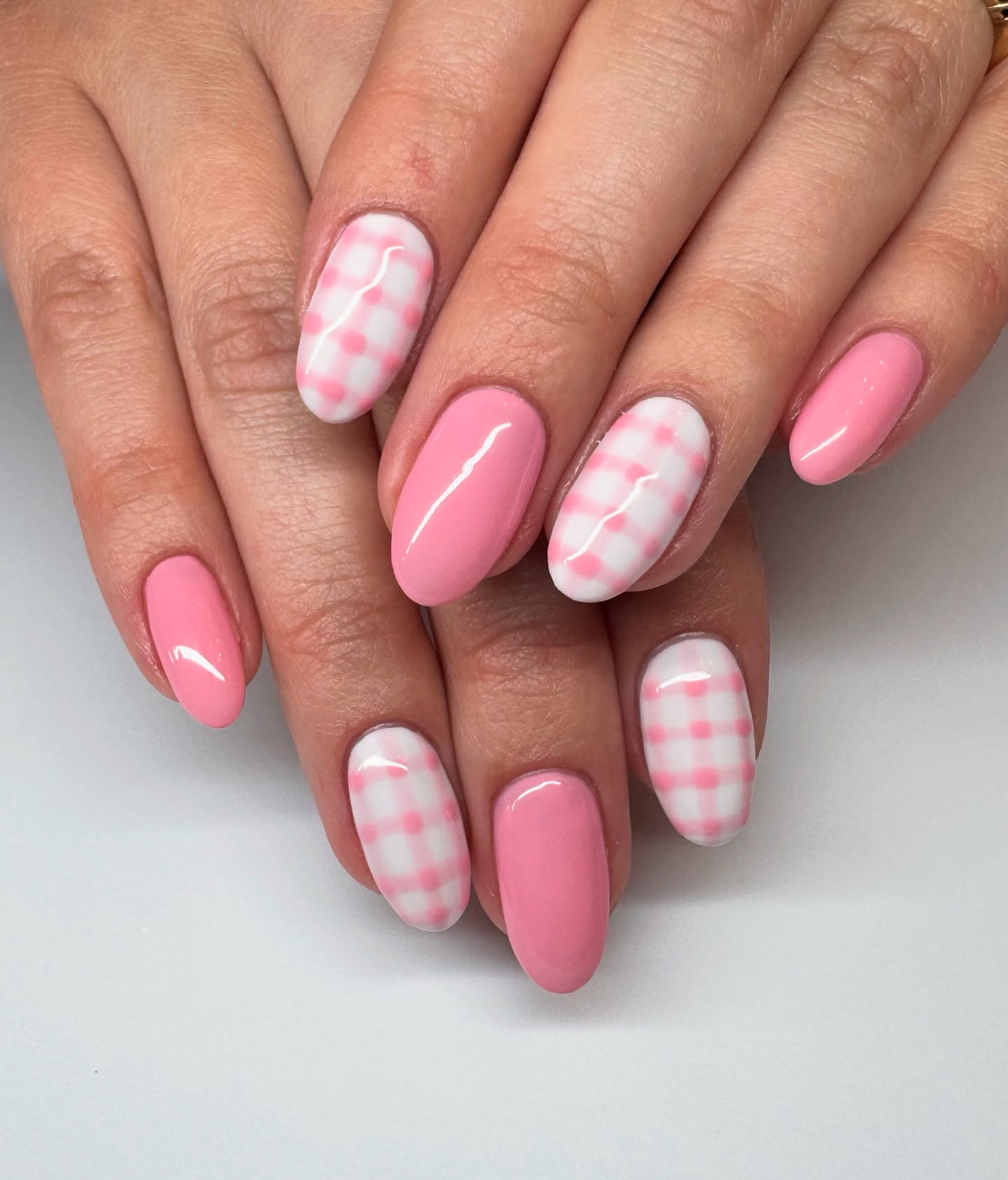 Short oval pink and white gingham check nails alternating with solid candy pink