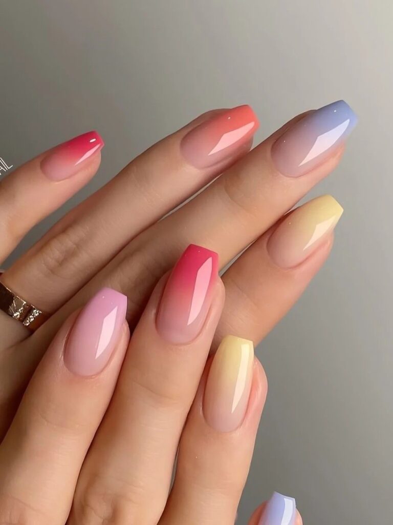 rainbow ombre tips in pink, coral, lilac, and yellow on a translucent base