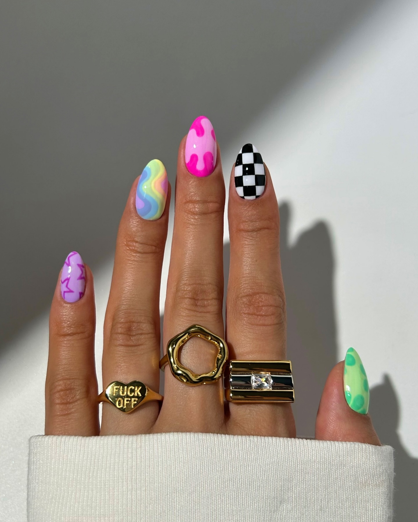 Maximalist almond nails with rainbow swirl pink blob and checkerboard