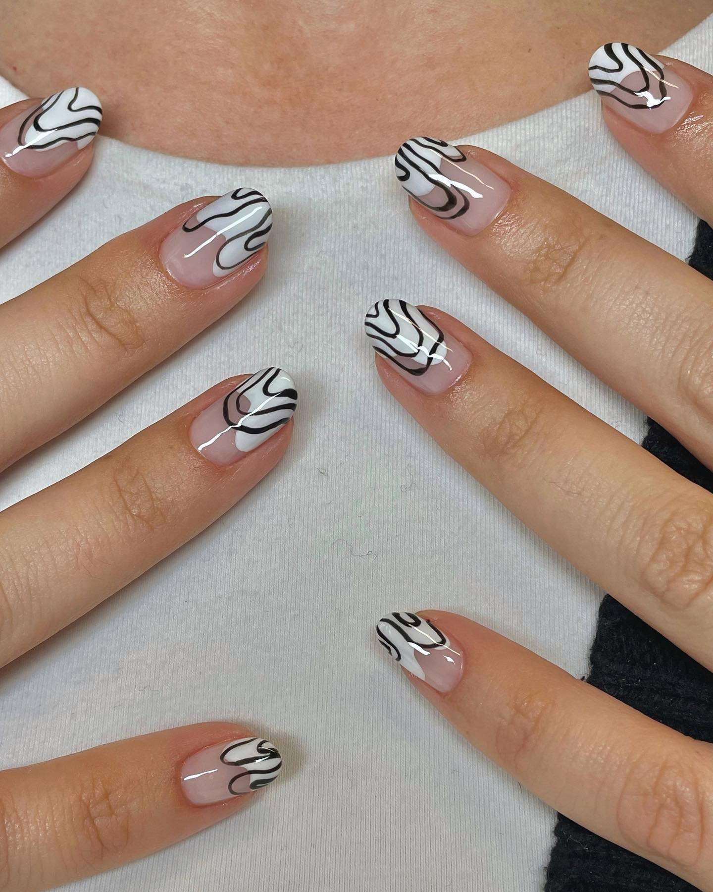 Almond nails with sheer base and black abstract swirl art